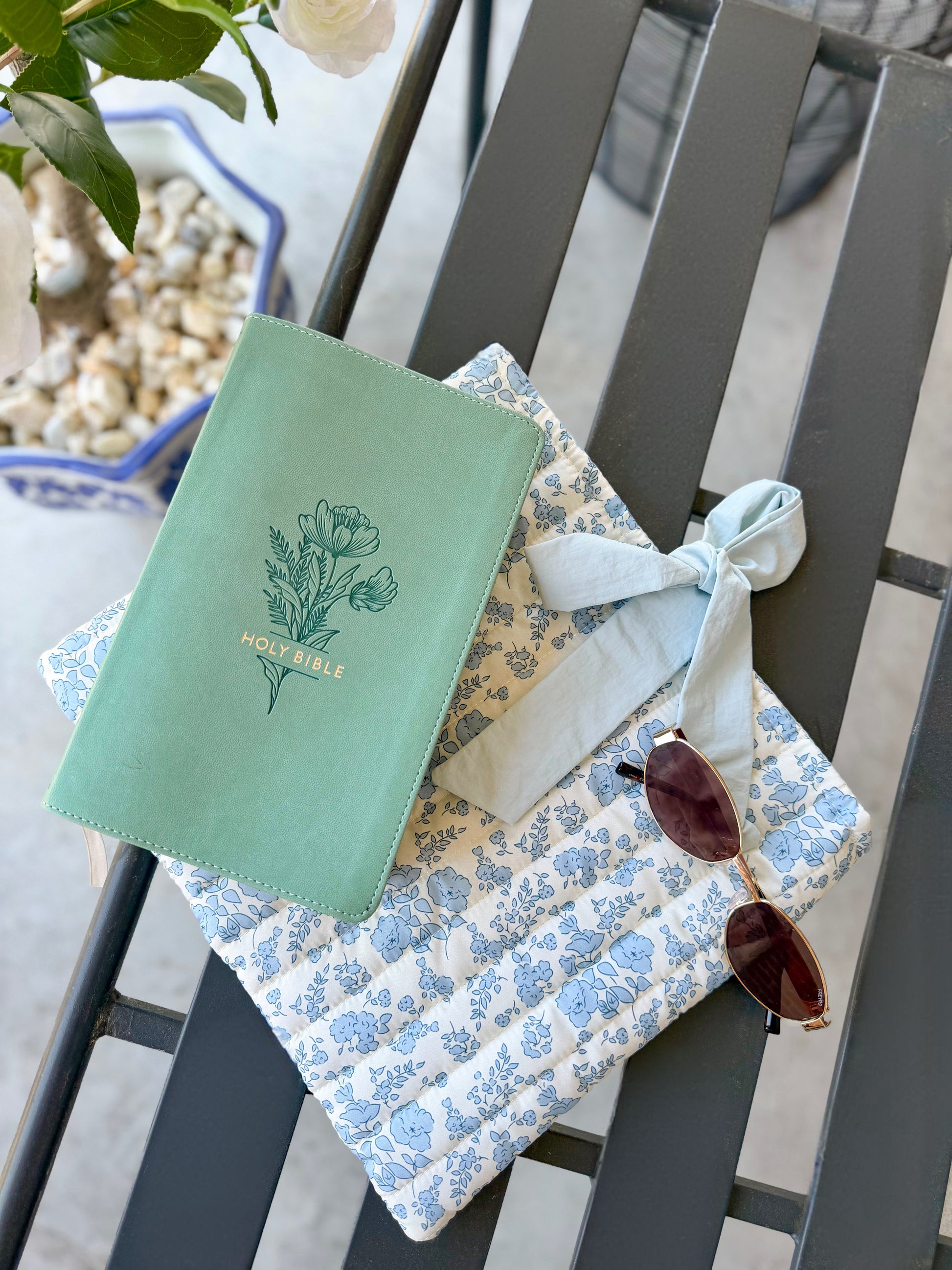 Blue quilted floral Bible cover with bow tie closure — a beautiful and practical accessory for your Bible or a thoughtful gift.