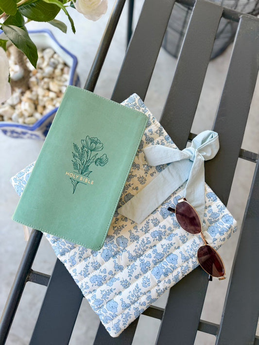Blue quilted floral Bible cover with bow tie closure — a beautiful and practical accessory for your Bible or a thoughtful gift.